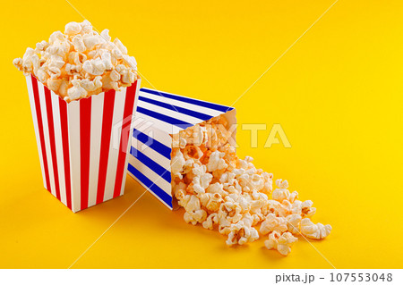 Glass with popcorn on a yellow background Glass with popcorn on a yellow background 107553048