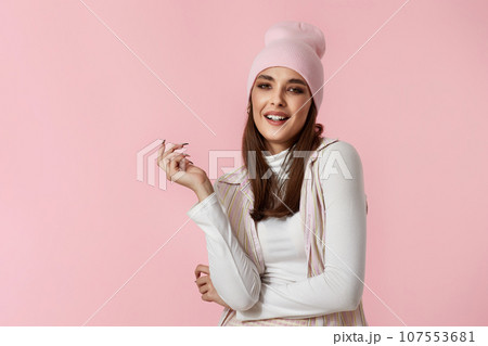 Happy playful young woman in pink hat, shirt and skirt 107553681