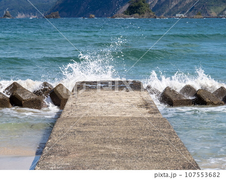 海岸の消波ブロックに波が打ち寄せて波飛沫が上がる。 海岸の消波ブロックに波が打ち寄せて波飛沫が上がる。 107553682