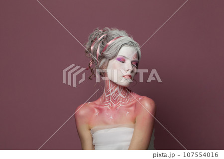 Fashion beauty portrait of young adult woman with Halloween makeup on pink background 107554016