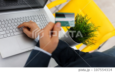 Male arms hold credit card press buttons Male arms hold credit card press buttons 107554314