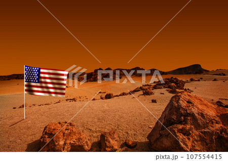 Planet landscape with American flag. Cosmic scene with desert, stone, sand Planet landscape with American flag. Cosmic scene with desert, stone, sand 107554415