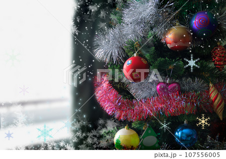 A fragment of a beautiful Christmas tree decorated and lit with gifts and ornaments. 107556005