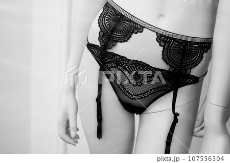 Closeup of black suspender belts on mannequin in a fashion store showroom 107556304