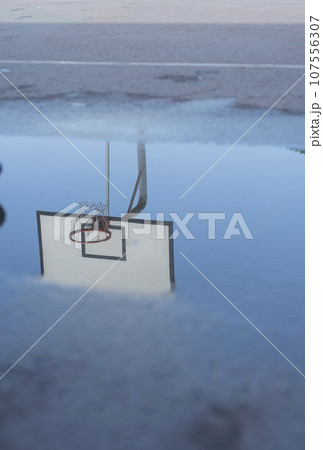 Reflection of a basketball ring in a puddle after the rain. 107556307