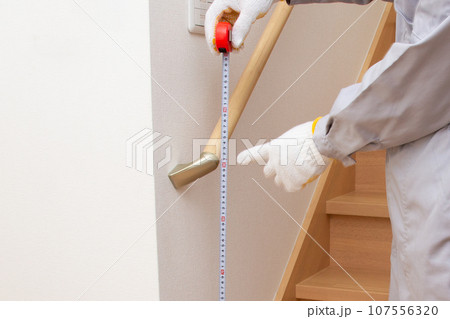 手すりの高さをコンベックスで確認する作業員 107556320