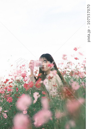 花畑の中で写真を撮る女性 107557070
