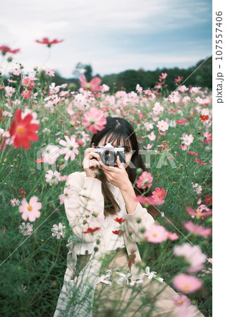 花畑で写真を撮る女性 107557406