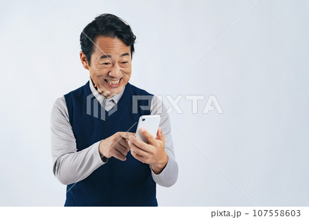 スマホを見て笑うミドル男性 スマホを見て笑うミドル男性 107558603