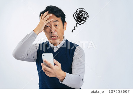 スマホを見て落ち込むミドル男性 107558607