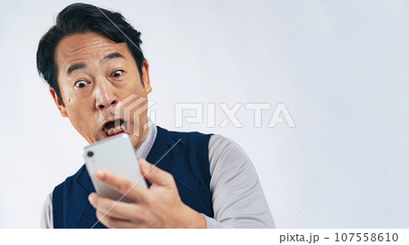スマホを見て驚くミドル男性 スマホを見て驚くミドル男性 107558610