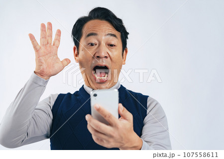 スマホを見て驚くミドル男性 スマホを見て驚くミドル男性 107558611