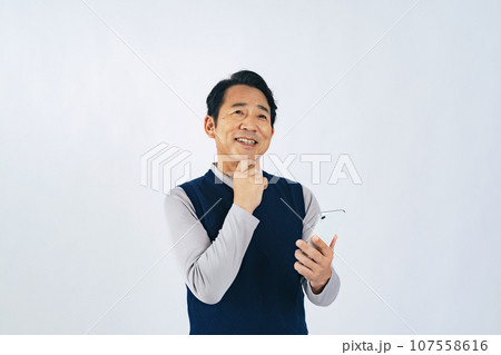スマホを見ながら考えるミドル男性 スマホを見ながら考えるミドル男性 107558616