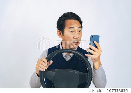運転しながらスマホを見るミドル男性 ながら運転 運転しながらスマホを見るミドル男性 ながら運転 107558636