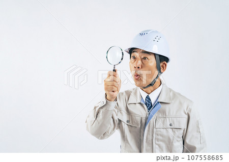 ルーペで見る作業服の中年男性　作業員　建設業者 107558685