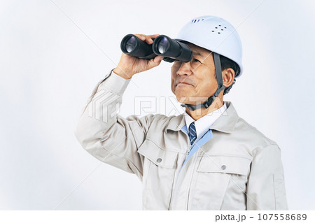 双眼鏡で遠くを見る作業服の中年男性　作業員　建設業者 107558689