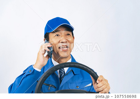 運転しながらスマホで通話する作業服の男性　作業員　運送業者　セールスドライバー 107558698