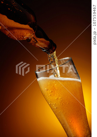 Pouring beer into a tall glass. 107559467