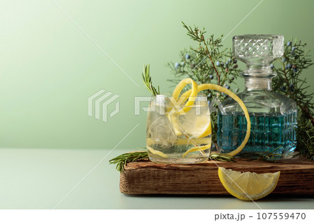 Cocktail gin-tonic with ice, lemon, and rosemary in a frozen glass. 107559470