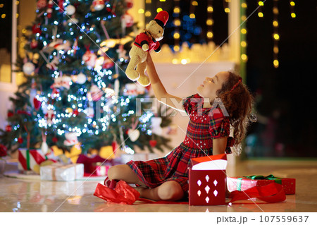 Kids at Christmas tree. Children open presents 107559637