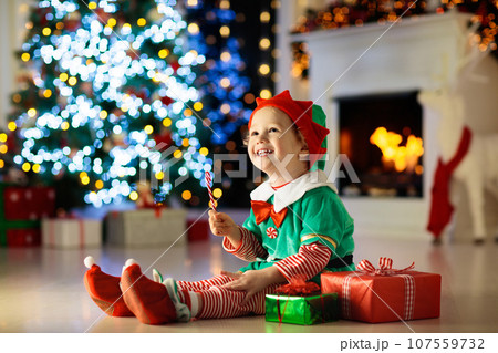 Kids at Christmas tree. Children open presents 107559732