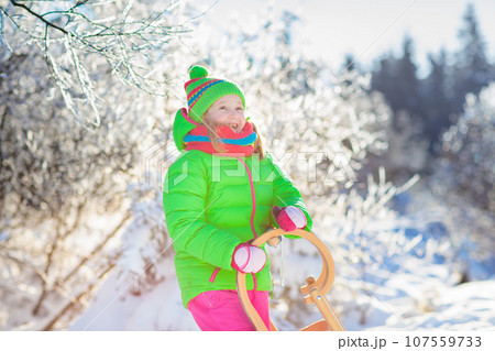 Baby boy on sled. Child sledding. Kid with sledge 107559733