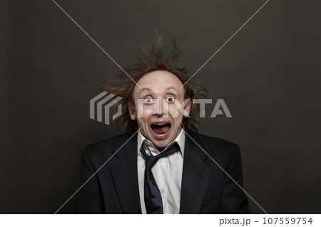 Funny surprised excited businessman with hair up and opened mouth posing on black background 107559754