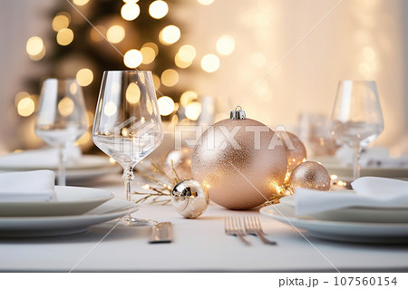 Beautiful table setting with Christmas decorations. Dishware, silverware and decorations on festive table, dinner table prepared for New Year's Eve. Christmas home decoration 107560154
