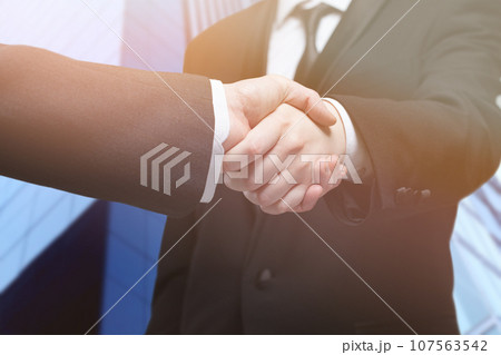 Business people shaking hands, finishing up a meeting 107563542