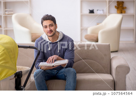 Young man looking after newborn at home Young man looking after newborn at home 107564564