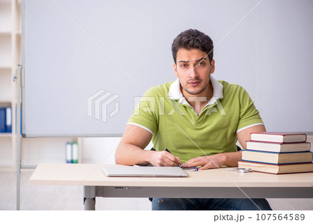 Young male student sitting in the classroom Young male student sitting in the classroom 107564589