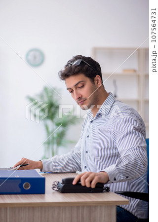 Young male employee working in the office Young male employee working in the office 107564731