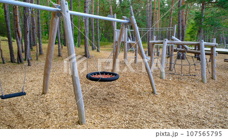 Empty children's playground in the park. Ecological children's park. Wooden structures Empty children's playground in the park. Ecological children's park. Wooden structures 107565795