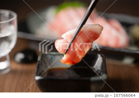 dipping blue fin fatty tuna slice into soy sauce dipping blue fin fatty tuna slice into soy sauce 107566064