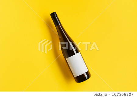 Wine bottle with blank label. Red wine on yellow background with copy space. 107566207