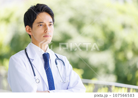 医療施設の廊下に立つ若い男性医師 医療施設の廊下に立つ若い男性医師 107566583