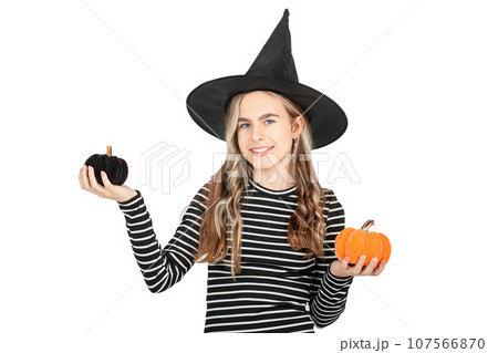Halloween celebration concept. Portrait smiling girl in black hat, holding decorative pumpkins on white background. 107566870