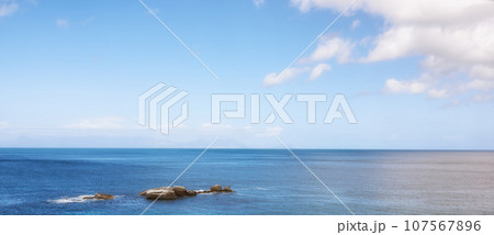 Beautiful view of a blue calm ocean on the rocky coast of Western Cape, South Africa, against a sunny sky background with copy space. Soothing, tranquil water in harmony with nature and fresh air Beautiful view of a blue calm ocean on the rocky coast of Western Cape, South Africa, against a sunny sky background with copy space. Soothing, tranquil water in harmony with nature and fresh air 107567896