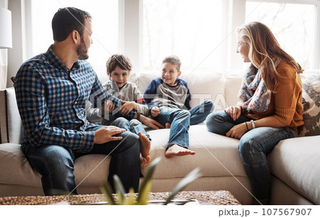 Family home, boy kids and parents on sofa with conversation, love or bonding for childhood development. Happy family, relax and sitting together in home living room for fun, happiness or quality time Family home, boy kids and parents on sofa with conversation, love or bonding for childhood development. Happy family, relax and sitting together in home living room for fun, happiness or quality time 107567907