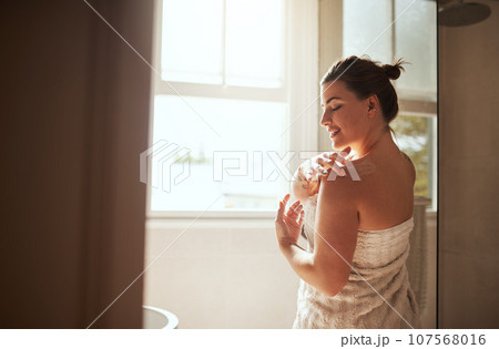 Skincare, cream and woman in bathroom for body wellness, moisturizer and apply lotion for healthy skin. Beauty, self care and female person for grooming, shower and cosmetics for hygiene at home Skincare, cream and woman in bathroom for body wellness, moisturizer and apply lotion for healthy skin. Beauty, self care and female person for grooming, shower and cosmetics for hygiene at home 107568016