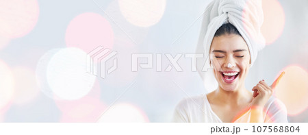 Woman, happy and beauty cream, skincare and funny morning routine on white background and bokeh overlay. Excited model with moisturizer, skin care and dermatology in studio and banner or mockup space 107568804