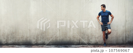 Ready, thinking and banner of a man in the city for fitness, exercise or training with motivation. Wall, idea and a male runner or athlete with mockup space to start a sport, running or urban cardio 107569067