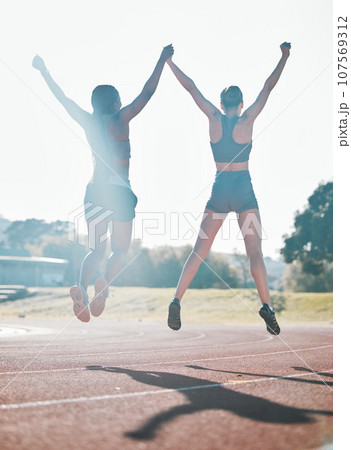 Friends, fitness and jump, women and celebrate, winning race and energy, wellness and health with support outdoor. Excited, people in air and cardio with sport, success and workout together with back 107569312