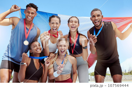 Happy and proud French olympic athletes celebrating winning medals for their country. Portrait of a diverse group of sports people with a French flag, cheering and proud of their success and victory Happy and proud French olympic athletes celebrating winning medals for their country. Portrait of a diverse group of sports people with a French flag, cheering and proud of their success and victory 107569444