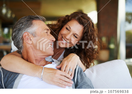 I love you. A handsome mature man being lovingly embraced by his smiling wife. 107569838