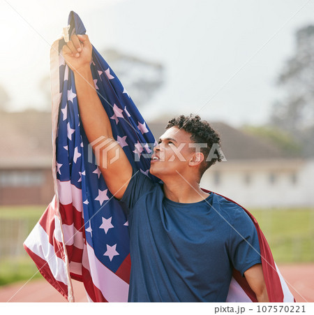 To the man upstairs. a handsome young male athlete pointing up at the sky while celebrating a victory for his country. 107570221