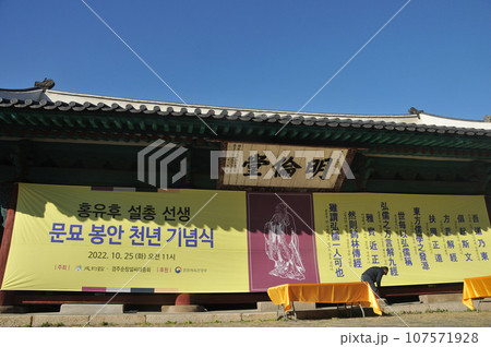 Poster of Confucius festival at Myeongryundang lecture hall of Sungkyunkwan University in Autumn. There is a construction worker pulls the poster. 107571928