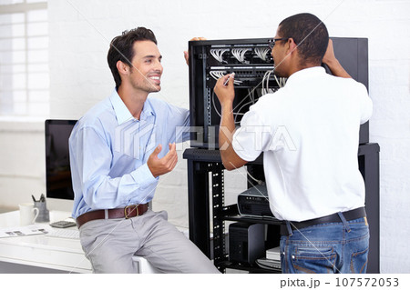 Staff, men and employees with server, internet connection and conversation for hardware update, consultation and tech support. Male people, technician and programmers with cyber security and network 107572053