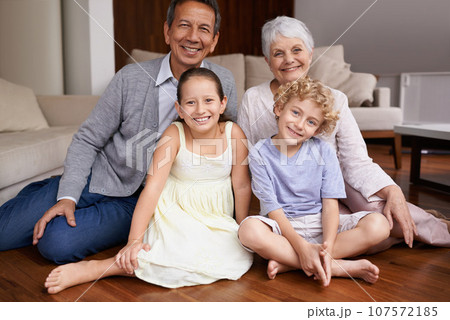Portrait, floor or happy grandparents with kids sit smiling together in family home in retirement. Senior grandma, smile or children siblings relaxing or bonding to enjoy quality time with old man 107572185