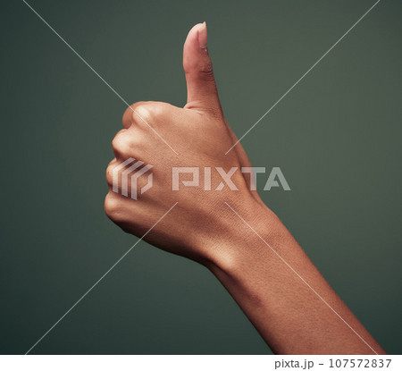 Thumbs up, hand gesture with emoji and agreement, person with approval and feedback isolated on green background. Yes, like and thank you, mockup space with OK sign and support closeup in studio 107572837